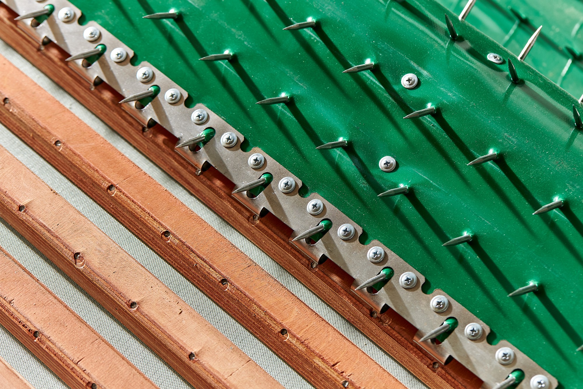 Green conveyor belt with wooden slats, steel pins and metal fasteners